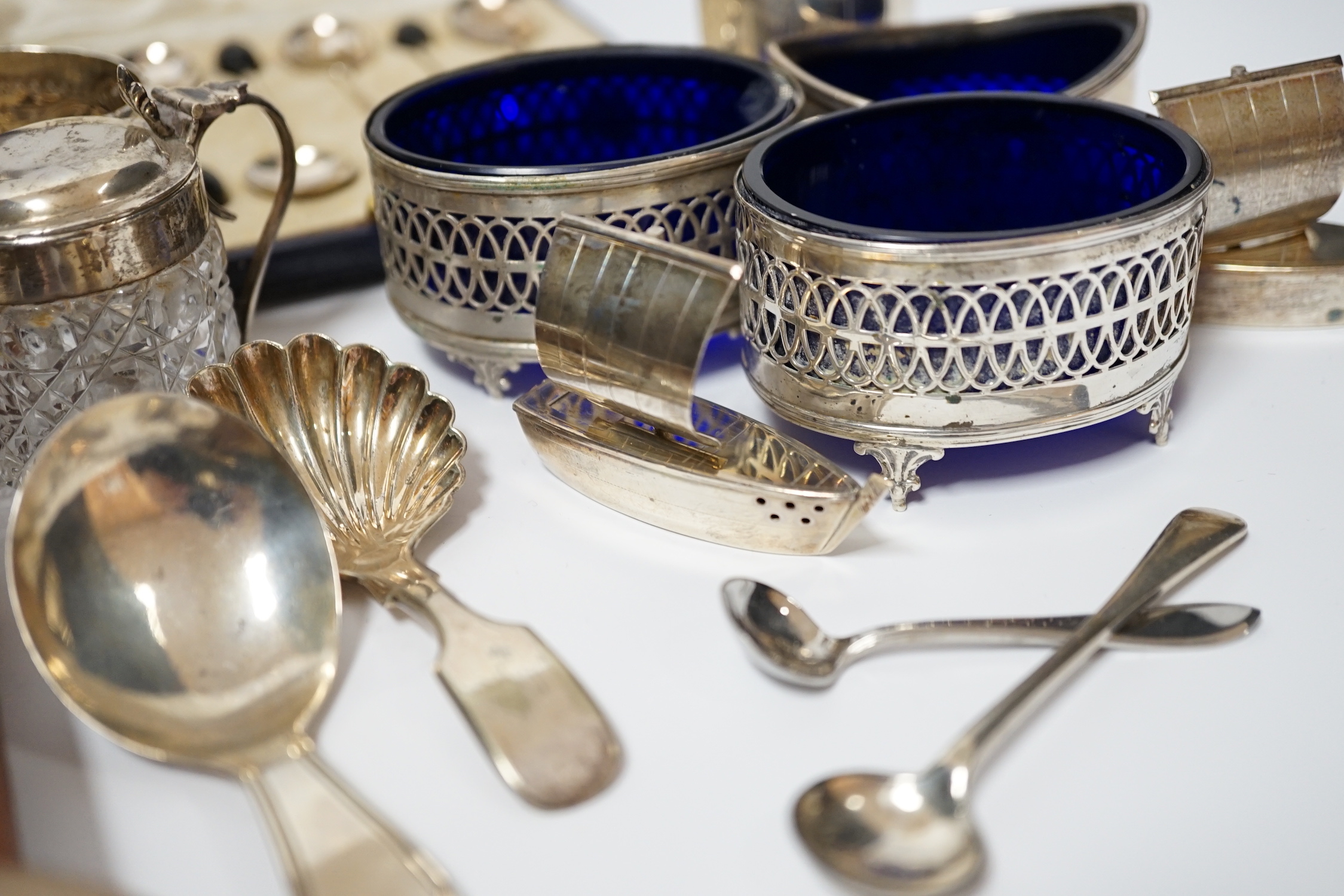 A white metal pepperette modelled as barrel and other silver and plated items including a Georgian caddy spoon, condiments, three cased sets of silver spoons, etc.